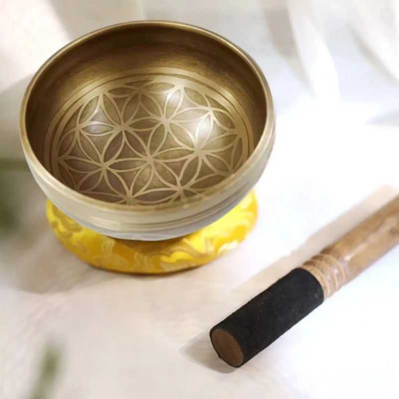Bol Tibétain Chantant Fleur de vie en 7 métaux sur coussin jaune, maillet en bois à côté, 8 cm de diamètre.