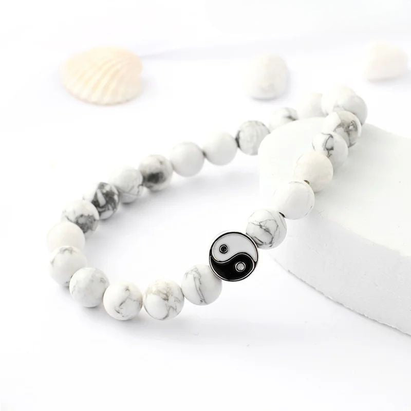 Bracelet Yin Yang en pierres naturelles de howlite blanche, orné d'une perle yin yang noire et blanche.