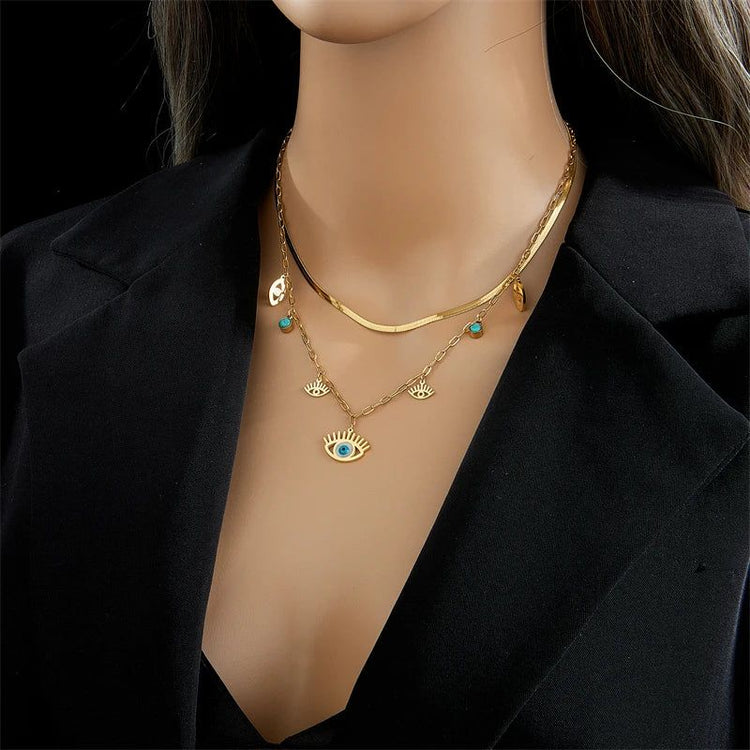 Collier Oeil Bleu en or porté par une femme en tenue élégante