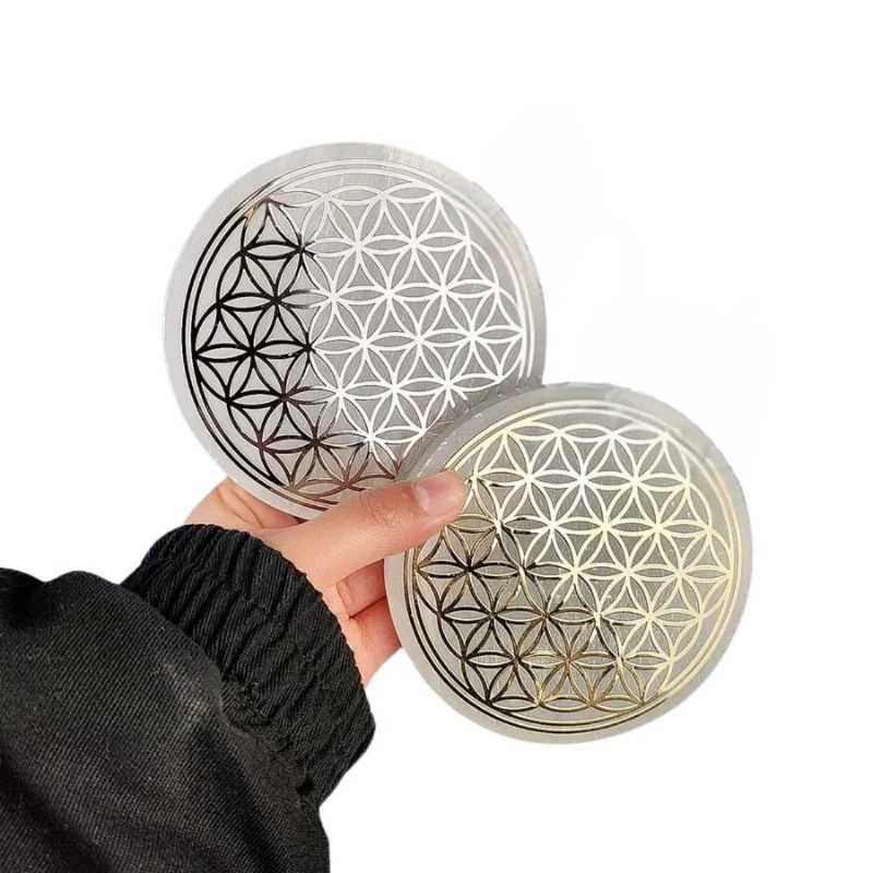 Fleur de vie en Sélénite de 10cm avec motif or et argent, tenue en main.