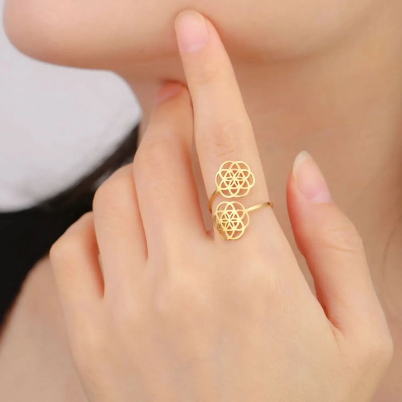 Bague Fleur de vie en Acier Inoxydable ajustable de couleur or portée sur une main de femme