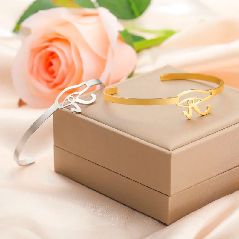 Comparaison des bracelets oeil d'horus or et argent sur une boite rose