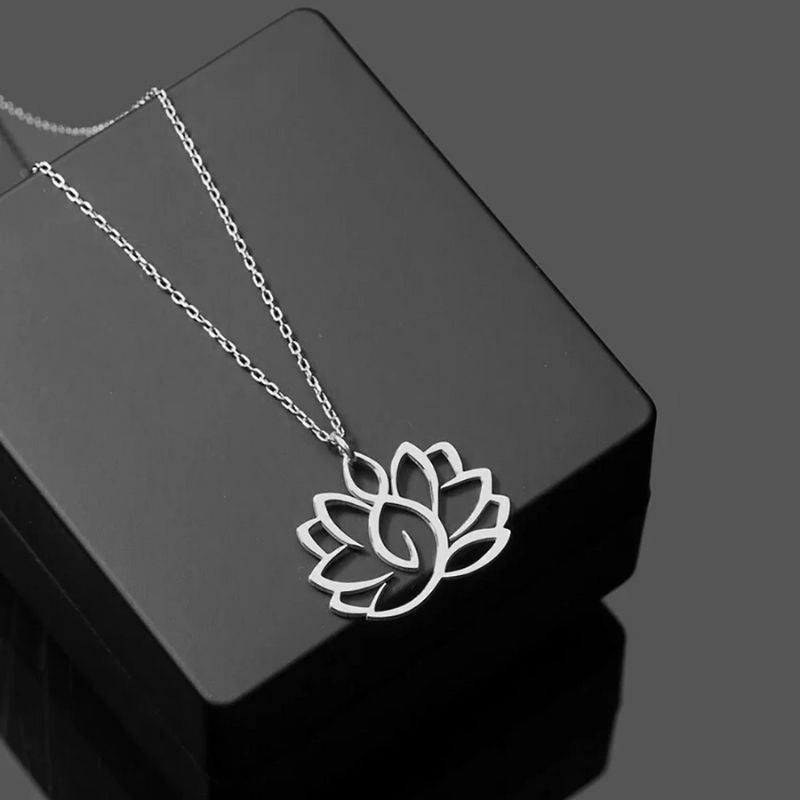 Collier Fleur de Lotus en argent sur fond noir, bijou minimaliste et spirituel idéal pour une touche délicate.
