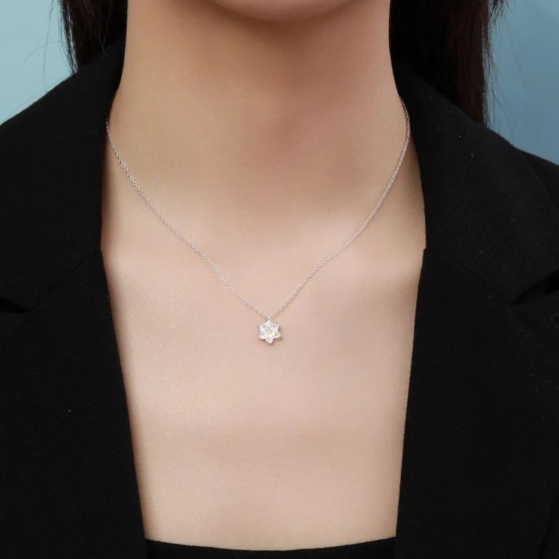 Collier Fleur de Lotus en argent porté par une femme en tenue noire, pendentif discret et élégant au creux du cou