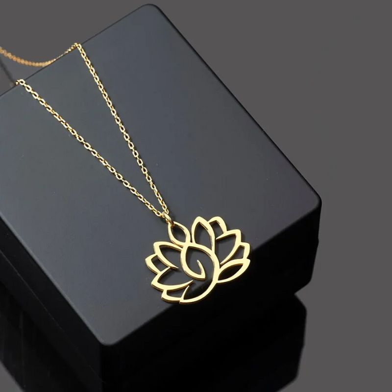 Collier Fleur de Lotus en or sur fond noir, accessoire symbolique et sophistiqué pour un style intemporel.