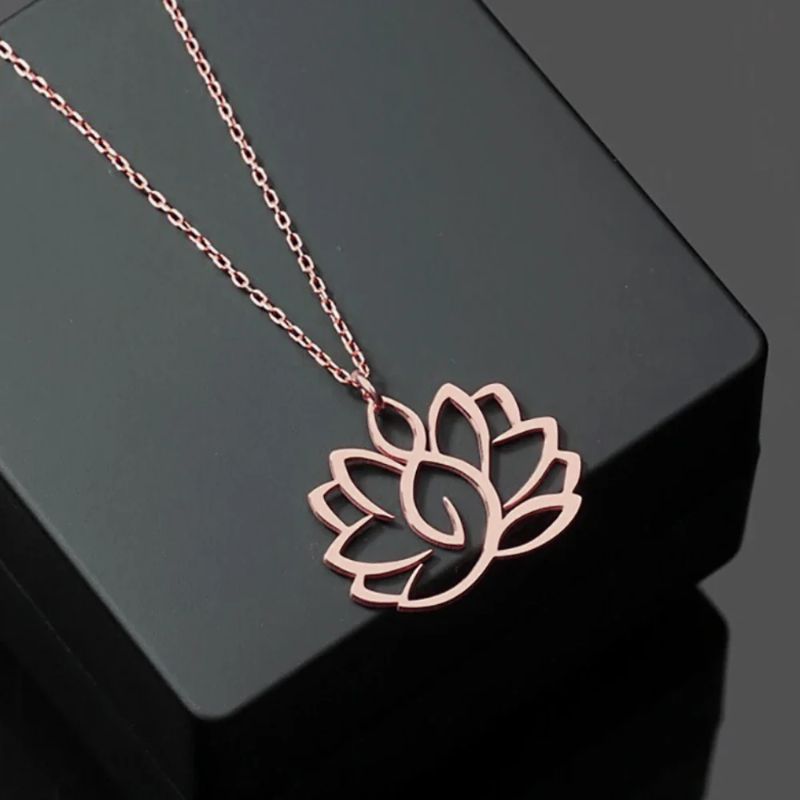 Collier Fleur de Lotus en or rose sur fond noir, mettant en valeur son design élégant et raffiné.