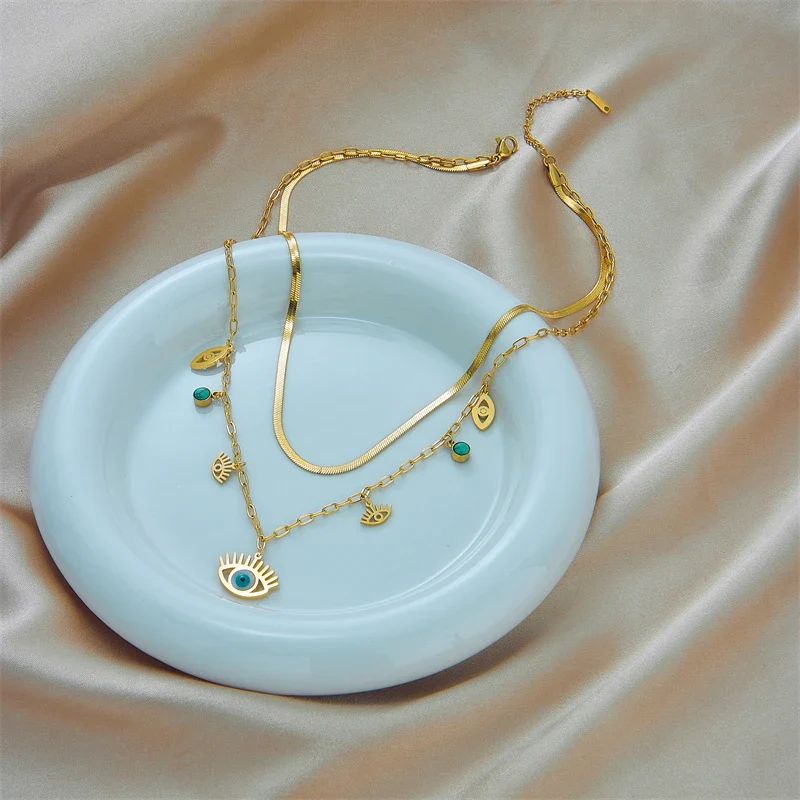 Collier Oeil Bleu Or posé sur une coupelle blanche