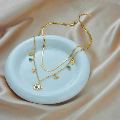 Collier Oeil Bleu Or posé sur une coupelle blanche