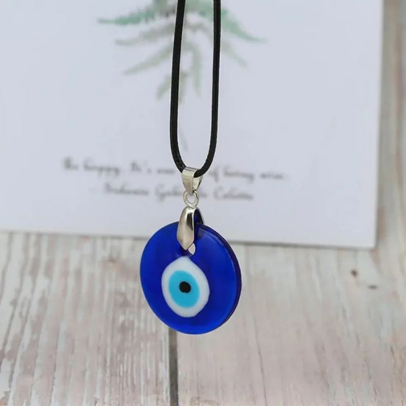 Collier avec pendentif œil protecteur en verre bleu, monté sur un cordon noir ajustable, idéal pour la protection spirituelle.