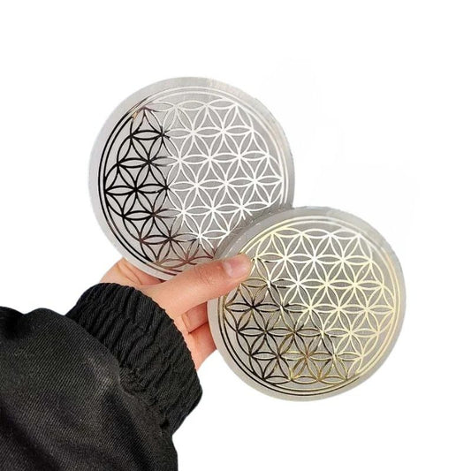 Fleur de vie en Sélénite de 10cm avec motif or et argent, tenue en main.