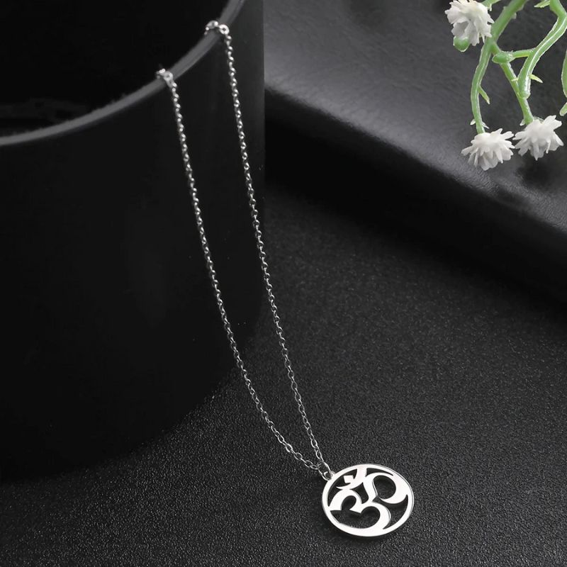 Collier avec pendentif Aum en argent sur fond noir, parfait pour une allure sobre et spirituelle