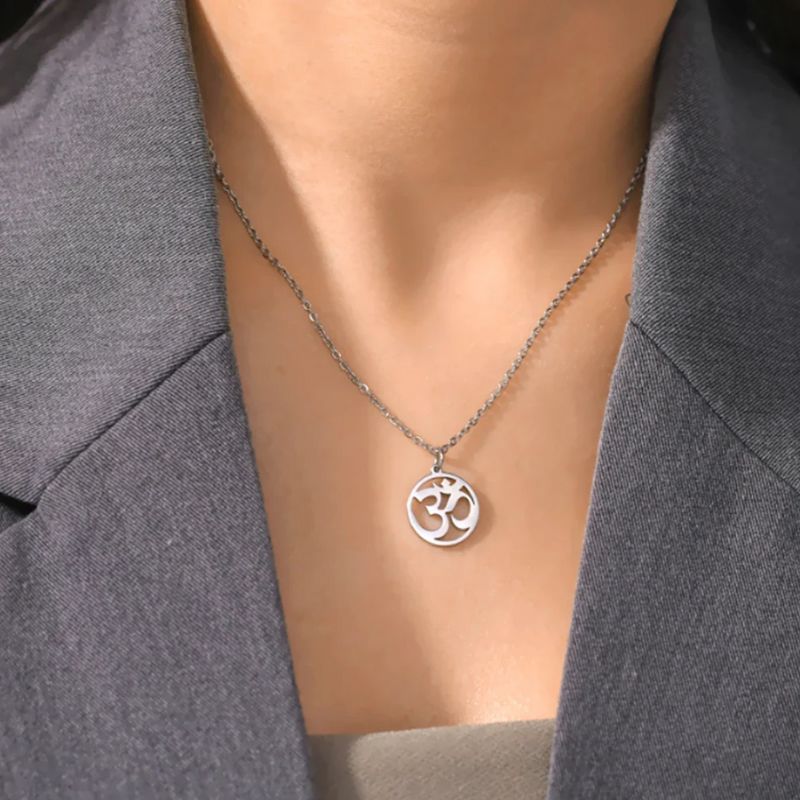 Pendentif Aum en argent porté par une femme, ajoutant une touche spirituelle et élégante à sa tenue.
