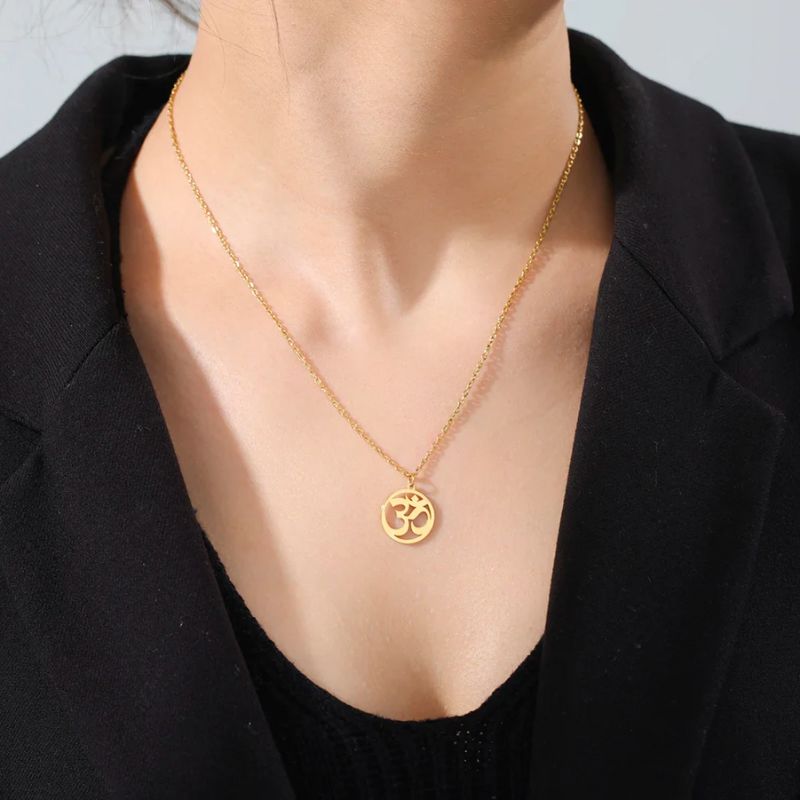 Pendentif Aum en or porté par une femme, bijou symbolique et raffiné pour un style intemporel.