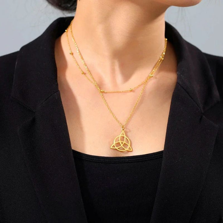 Pendentif Triquetra en acier inoxydable finition or porté par une femme